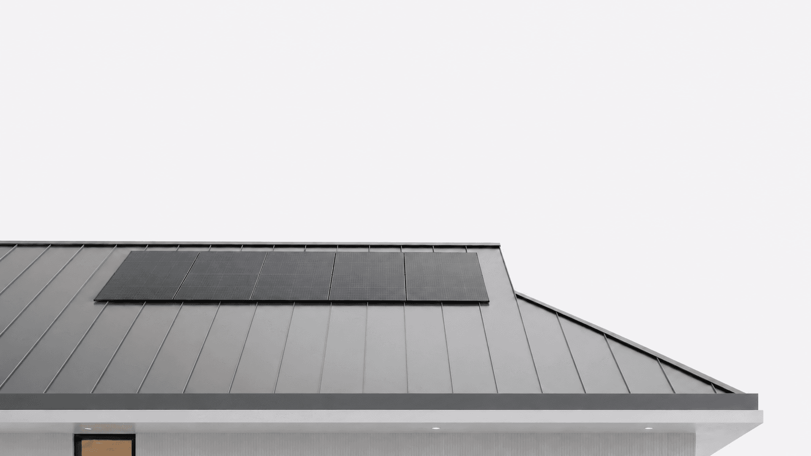 Solar panels on the standing-seam metal roof of a modern home
